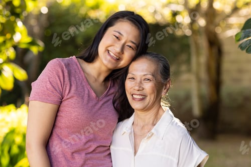 Preview: Smiling granddaughter and asian grandmother posing together outdoors, enjoying time