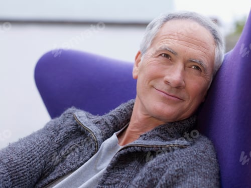 Preview: Portrait of senior caucasian man resting on sofa and looking away