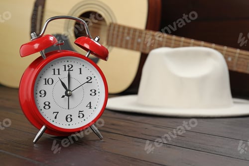 Preview: Alarm clock, hat and guitar on wooden background