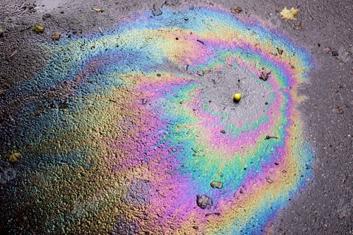 Preview: Petrol on the asphalt a big polluted puddle water. A rainbow slick of gasoline