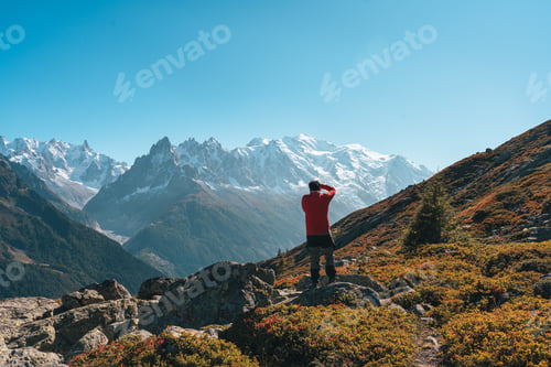 Preview: Male hiker standing and enjoying the Mont Blanc massif during trail to Lac Blanc in autumn