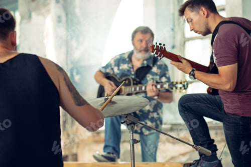 Preview: Repetition of rock music band. Electric guitar player and drummer behind the drum set.