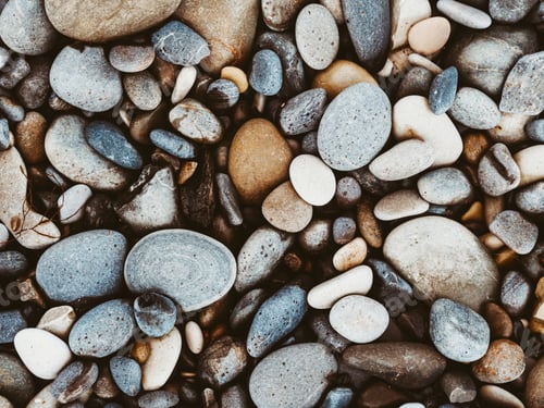 Preview: Group of white, brown, grey and black pebbles. Nature textured background.