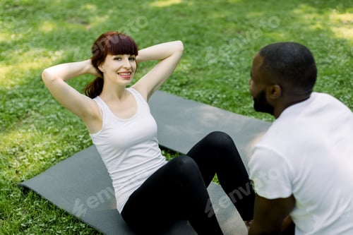 Preview: Pretty smiling young Caucasian woman exercising