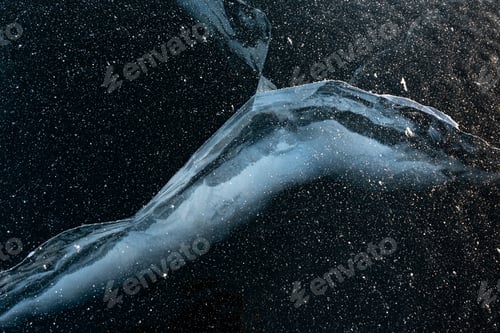 Preview: Natural blue ice on the lake. Beautiful winter landscape. Cracks in the ice. Frozen lake surface.