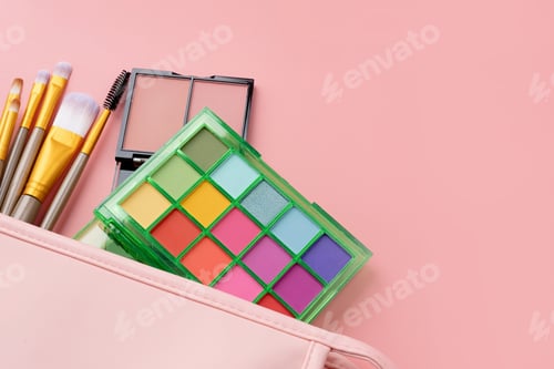 Preview: Bright summer eyeshadow palette and makeup products in pink cosmetic bag on pink background
