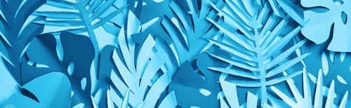 Preview: seamless pattern of blue exotic paper cut palm leaves on blue background with copy space, panoramic