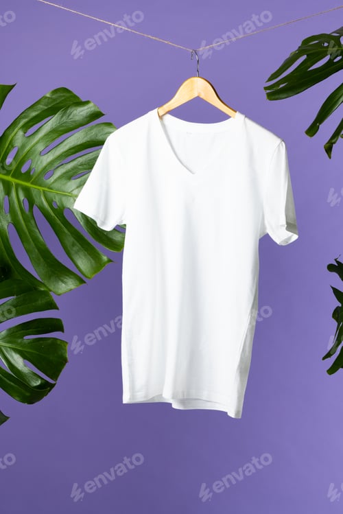 Preview: Tshirt hanging on coat hanger and copy space on purple background