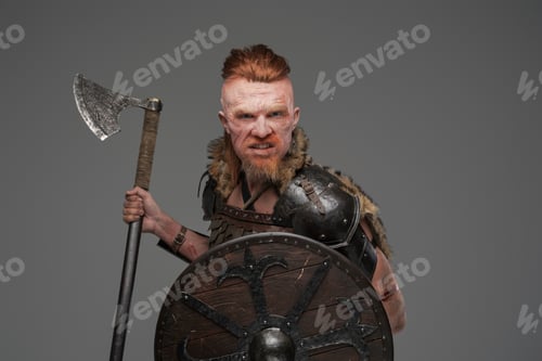 Preview: Mad redhead viking with shield and axe isolated on gray