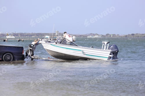 Preview: Fishermen launching a motor boat from the trailer into the water