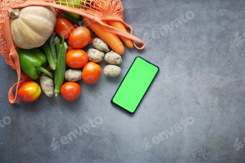Preview: top view of smart phone with fresh vegetable on table