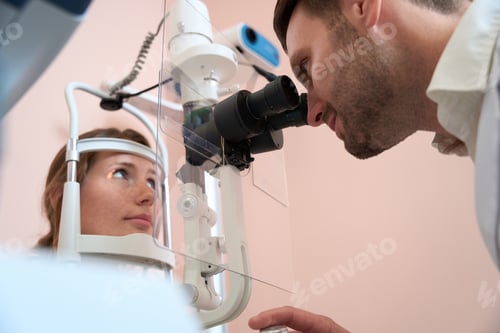 Preview: Caucasian lady receiving qualified examining her eyesight in optometrist office
