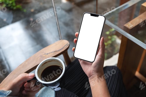 Preview: Mockup image of hands holding mobile phone with blank desktop screen while drinking coffee