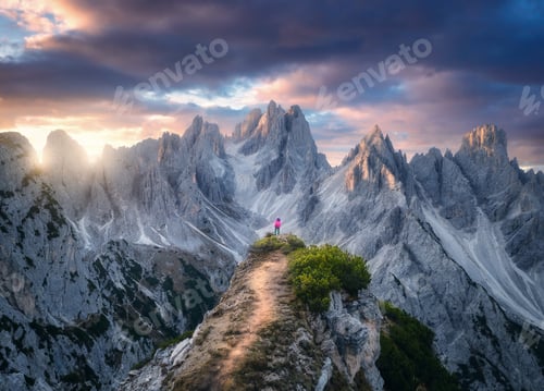 Preview: Aerial view of girl on the mountain peak and rocks at sunset