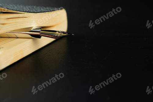 Preview: Black notepad with pen on black table close up