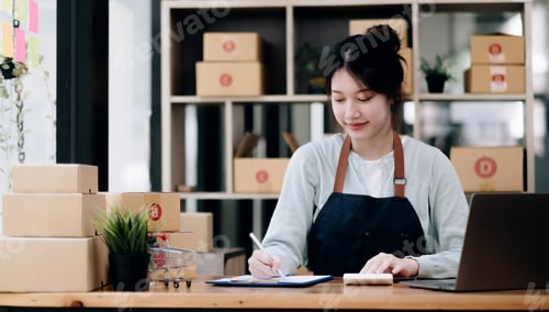 Preview: A portrait of a young Asian woman, e-commerce employee sitting in the office full of packages in the