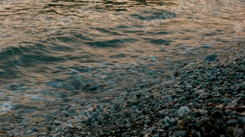 Preview: Beach.Creative.A rocky shore on which the sea waves rush and knock on the pebbles.