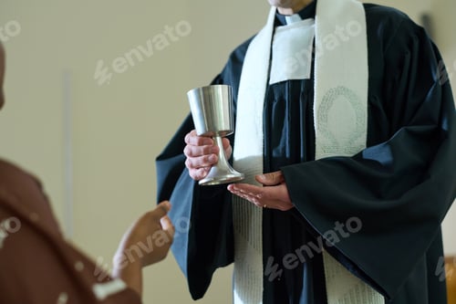 Preview: Clergyman of Catholic church holding cup with wine for oblation rite