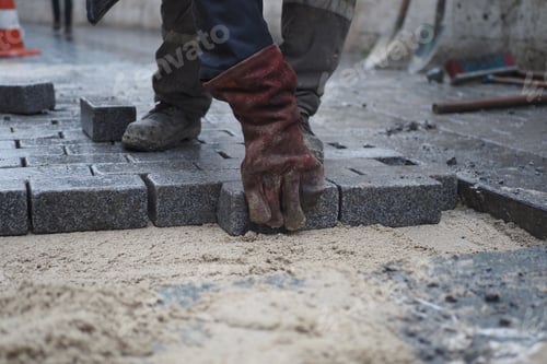 Preview: Skilled Laborer Engaged in Laying Pavers at Construction Site for Outdoor Infrastructure