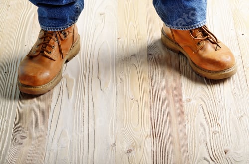 Preview: Carpenter feet in work boots standing on wooden floor. Place for
