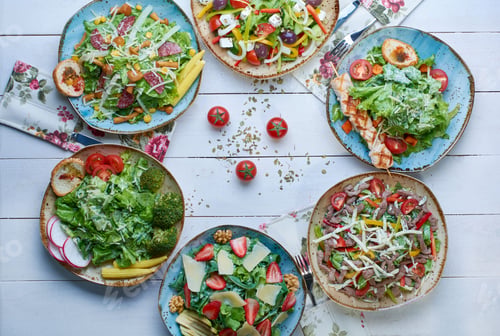 Preview: Closeup of delicious Rainbow salads on a wooden table