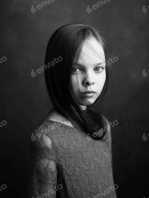 Preview: Portrait of a little girl in a dress on a dark gray background photograph cropped side view