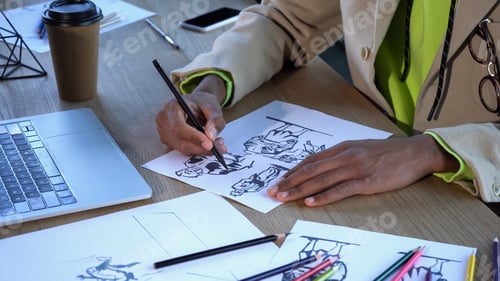 Preview: Cropped view of african american designer drawing sketches near laptop and coffee in studio