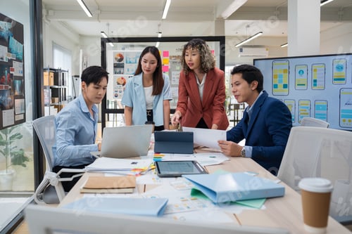 Preview: Group of young Asian business people team meeting in modern office working
