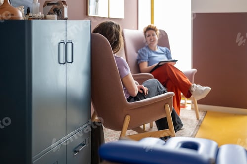 Preview: Two people having a conversation in a colorful room.