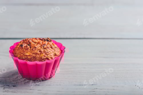Preview: Fresh baked muffin inside hot pink baking cup