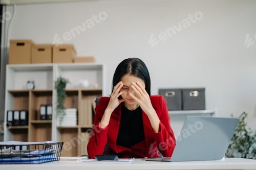 Preview: Asian business woman is stressed, bored, and overthinking from working on a tablet at office.
