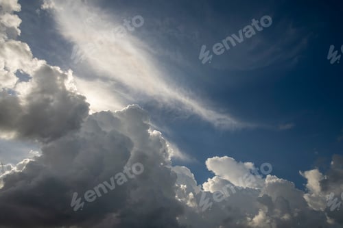 Preview: White fluffy cumulonimbus clouds forming before thunderstorm on summer blue sky.
