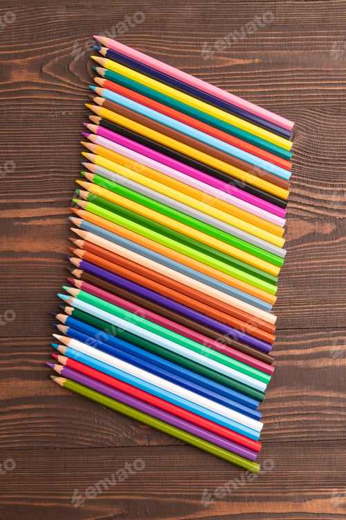 Preview: Set of watercolor pencils on brown wooden. Top view