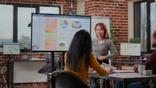 Preview: Multi ethnic team attending business presentation with charts