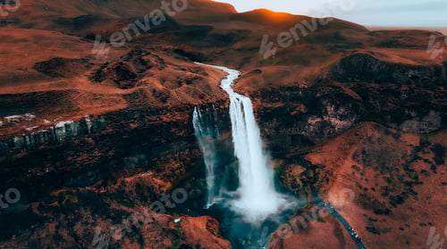 Preview: the sun is setting over the mountains and a waterfall with water