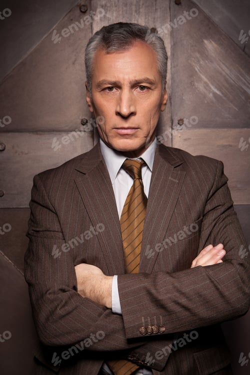 Preview: Power at his eyes. Confident senior man in formalwear holding arms crossed and looking at camera