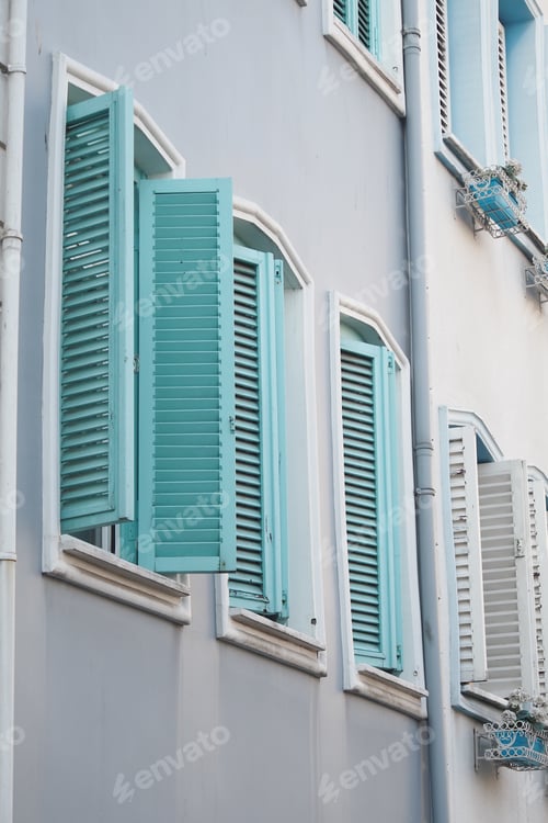 Preview: Mediterraneanstyle windows with blue shutters shine on a sunny day, creating a beautiful scene