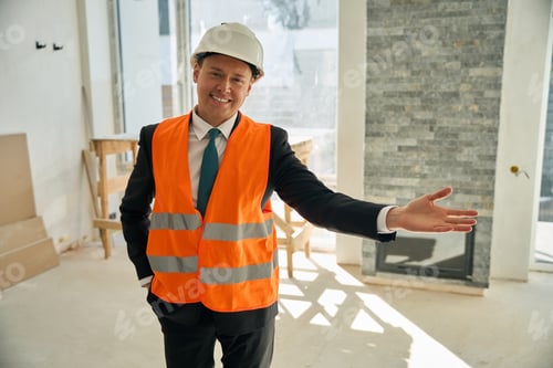 Preview: Happy foreman standing in room and invites someone to enter