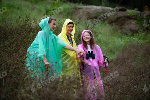 Preview: Group of friends in raincoats with backpacks on a hike in the forest, Prepare to hiking