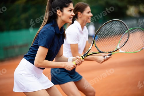 Preview: Young happy women friends playing tennis at tennis court