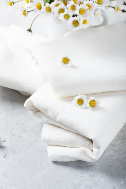 Preview: wild daisy flowers and white linen tablecloth