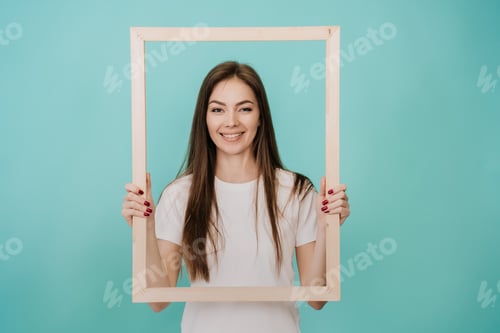 Preview: Young Italian woman with long hair in a white T-shirt stands on a turquoise background