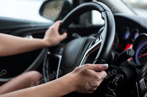 Preview: Women's hands on the steering wheel, inside the car.