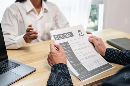Preview: A man and a woman are sitting at a table with a resume in front of them