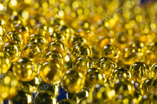 Preview: yellow medical capsules on a mirror surface