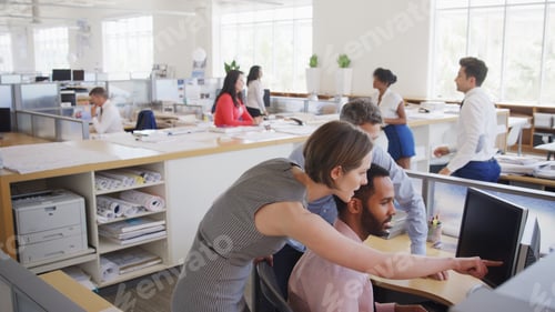 Preview: Multi-Cultural Business Team Meeting Around Desk In Modern Open Plan Architects Office Together