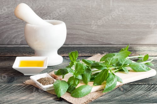 Preview: Basil on a chopping board and olive oil on a wooden background