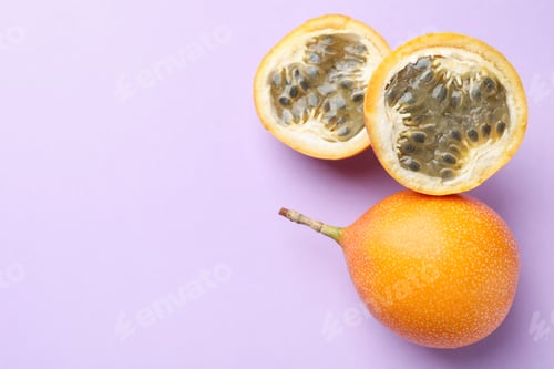 Preview: Ripe yellow passion fruits on lilac background, flat lay. Space for text