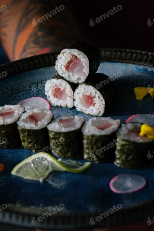 Preview: Anonymous waiter with delicious sushi rolls with salmon on tray