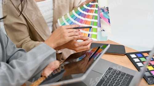 Preview: Two of a graphic designers are discussing and planning the web colour for their project together.